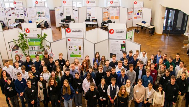 Große Gruppe von Schülern steht in einem Saal